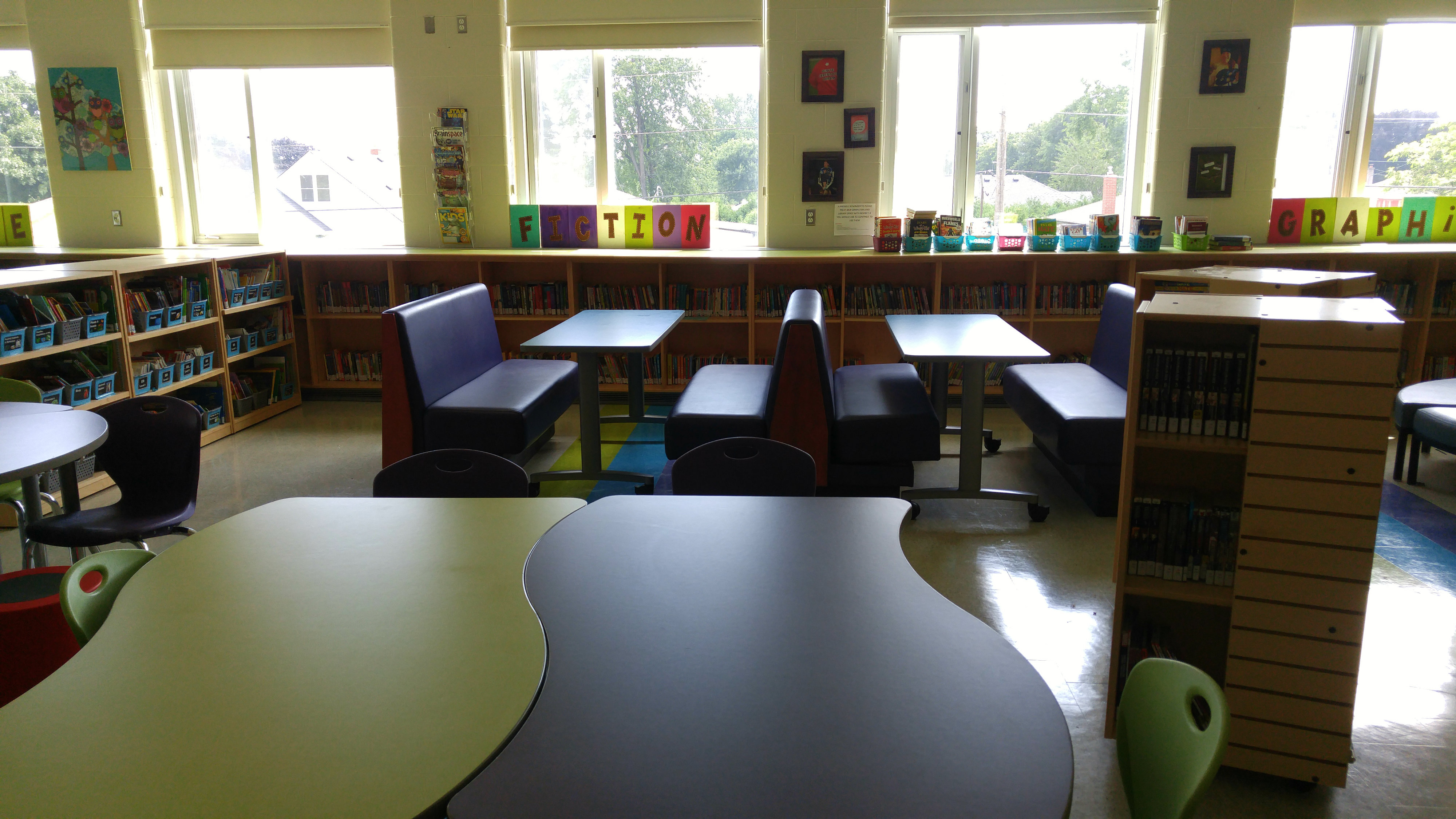 purple benches by a window for seating in a library